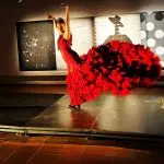 Bailaora posando en un tablao flamenco, mostrando su arte y vestuario tradicional