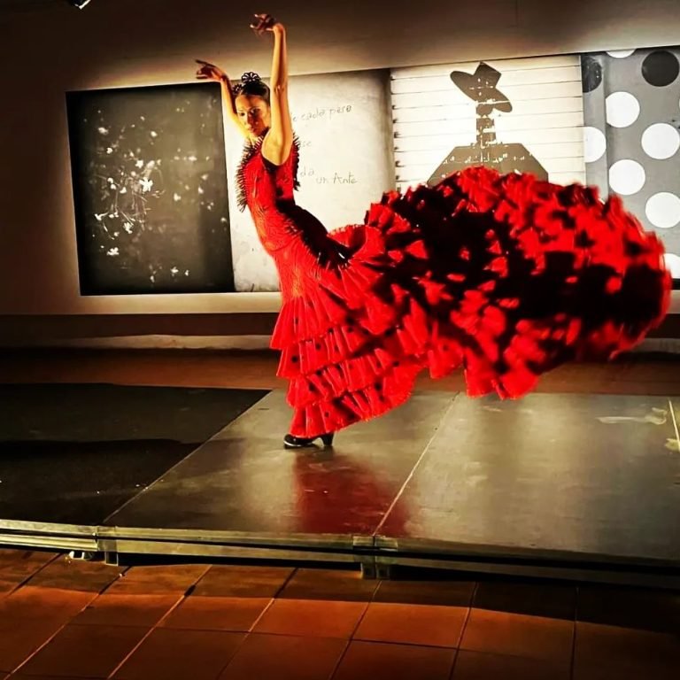 Bailaora posando en un tablao flamenco, mostrando su arte y vestuario tradicional